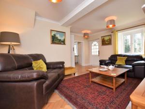 a living room with a leather couch and a coffee table at 4 Bed in Barnstaple oc-73949 in Stoke Rivers