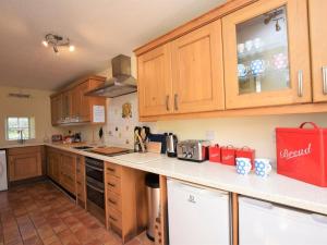 a kitchen with wooden cabinets and a counter top at 4 Bed in Barnstaple oc-73949 in Stoke Rivers +19 photos
