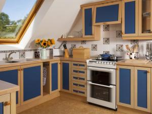 a kitchen with blue and white cabinets and a stove at 2 Bed in Brecon oc-bn077 in Llandefaelogfâch +8 photos