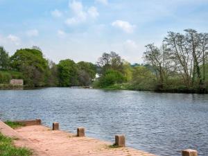 a lake with a wooden dock in the middle at 2 Bed in Brecon oc-bn077 in Llandefaelogfâch