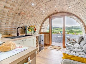 a kitchen and living room with a couch and a table at 1 Bed in Brecon oc-95630 in Aber-Brân