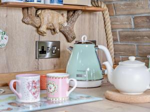 a tea kettle and two cups on a table at 1 Bed in Brecon oc-95630 in Aber-Brân