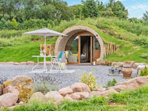 a garden room with an umbrella and a table at 1 Bed in Brecon oc-95630 in Aber-Brân