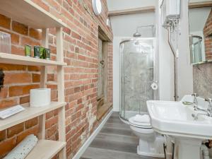 a brick walled bathroom with a sink and a toilet at 1 Bed in Craven Arms oc-54928 in Clungunford +17 photos