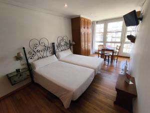 a bedroom with two beds and a dining room with a table at InsideHome Porta do Sol in Vigo +102 photos