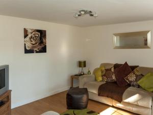a living room with a couch and a television at 2 Bed in Neath oc-bn247 in Crynant