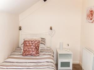 a white bedroom with a bed with a pillow on it at 2 Bed in Neath oc-bn247 in Crynant