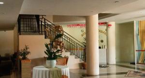 a lobby with a table with a vase with flowers on it at Hotel Melayu Bedendang in Tanjunguban