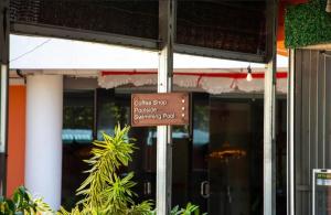 a brown sign on a pole in front of a building at Hotel Melayu Bedendang in Tanjunguban
