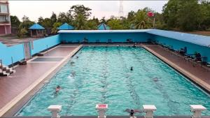 a swimming pool with people in the water at Hotel Melayu Bedendang in Tanjunguban