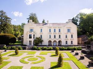 an exterior view of a large white house with a garden at 1 Bed in Llandovery oc-88603 in Cynghordy