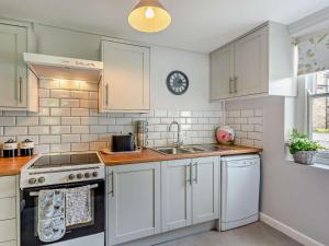 a kitchen with white cabinets and a sink at 2 Bed in Bideford oc-40281 in Northam +9 photos