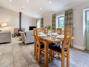 a dining room with a table and chairs and a living room at 2 Bed in Pontypool oc-58962 in Mamhilad