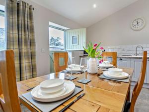 a dining room with a table with plates and wine glasses at 2 Bed in Pontypool oc-58962 in Mamhilad +11 photos