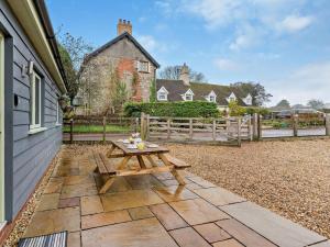 a wooden picnic table on a patio in front of a house at 2 Bed in Pontypool oc-58962 in Mamhilad