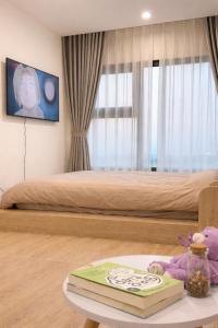 a bedroom with a bed with a teddy bear on a table at Homestay Nhà Thu Thu Vinhome Ocean Park in Gia Lâm Pho