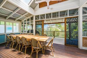 a dining room with a table and chairs on a deck at Rancho Crescent Head in Crescent Head