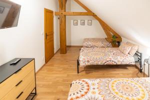 a attic room with two beds and a dresser at Jolie maisonnette in Barenton-Bugny