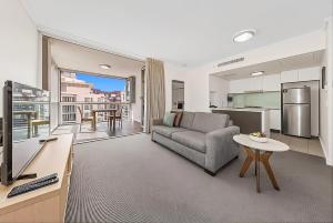 a living room with a couch and a tv and a kitchen at CITY Centre With Awesome Views! in Brisbane