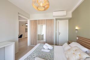 a bedroom with a large bed and a mirror at Sweett - Maison Blanche in Juan-les-Pins
