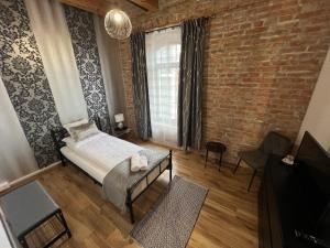 a bedroom with a bed and a brick wall at Tejmalom Szálló in Sárrétudvari