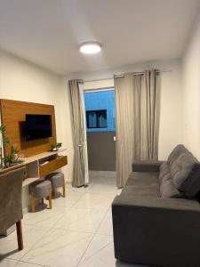 a living room with a couch and a television at Lisboa in João Pessoa
