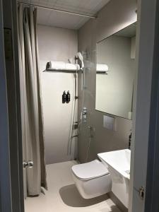 a bathroom with a toilet and a sink and a mirror at HYVE Siliguri in Siliguri +13 photos