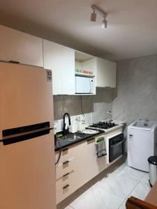 a kitchen with white cabinets and a refrigerator at Lisboa in João Pessoa