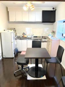 a kitchen with a table and chairs in it at The Village House 1 in Hadano