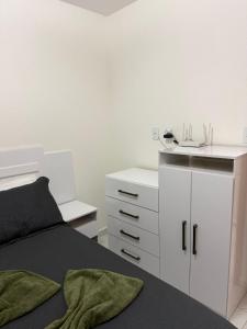 a bedroom with a bed and a white cabinet at Lisboa in João Pessoa