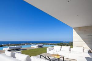 a living room with a white couch and a table at Oliva D'oro Villa - Sunset Gaze by etouri in Chania