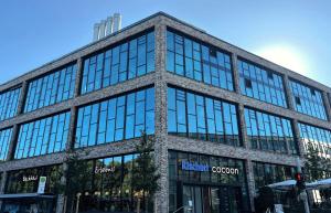 un grand immeuble en verre dans une rue de la ville dans l'établissement Cocoon München Theresienwiese, à Munich