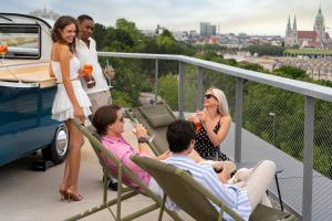 un groupe de personnes assises sur un balcon dans l'établissement Cocoon München Theresienwiese, à Munich