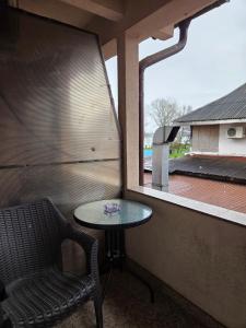 a table and a chair in a room with a window at Pensiunea La Iani in Constanţa
