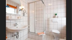 a white bathroom with a sink and a toilet at Zum Fahrensmann in Norddorf +47 photos