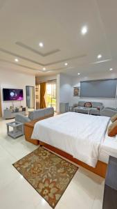 a large bedroom with a large bed and a living room at 3Apartments in Lagos