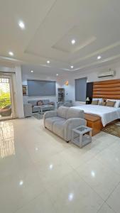a large bedroom with two beds and a flat screen tv at 3Apartments in Lagos +12 photos