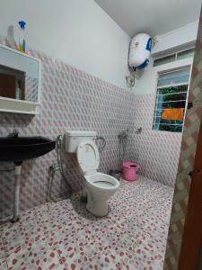 a bathroom with a toilet and a sink at Pine Forest Home stay with City View in Shillong +107 photos
