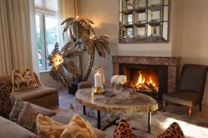 a living room with a fireplace and a table at Hotel Van Cleef in Bruges