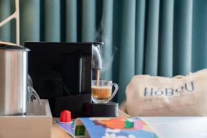 a coffee maker sitting on top of a table with a drink at Hôbou - ex Hotel Acanthe in Boulogne-Billancourt