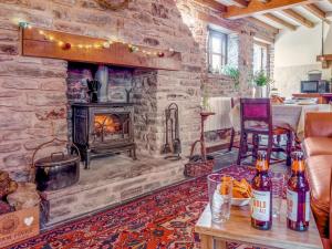 a stone fireplace in a living room with a stove at 1 Bed in Usk- oc-79936 in Llandenny