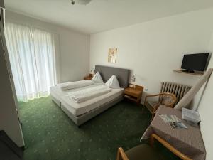 a hotel room with two beds and a television at Garni Franz Leiter in Lagundo