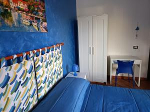 a blue bedroom with a bed and a desk at A due passi dal mare in Capo dʼOrlando