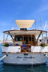 a boat sitting in the water with flowers on it at Sea Panther in Il-Gżira
