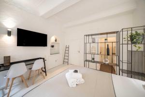 a living room with a tv and a table and chairs at Cozy Studio A C 2P - Saint-Tropez in Saint-Tropez