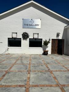a white building with a sign on the side of it at The Gallery in Franskraalstrand