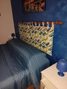 a bedroom with a bed with a blue wall at A due passi dal mare in Capo dʼOrlando