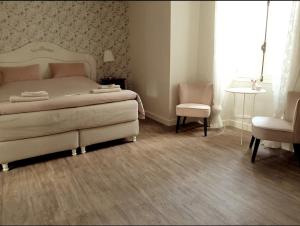a bedroom with a bed and a table and chairs at La P'tite Place in Les Arques