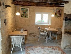 a room with two tables and chairs and a window at La P'tite Place in Les Arques