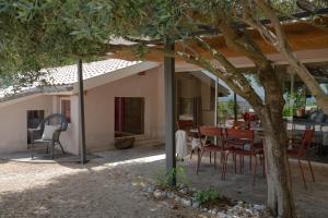 a house with a table and chairs under a tree at MiHotel Le Gourguillon in Lyon